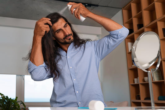 Man using heat protectant spray before hair drying