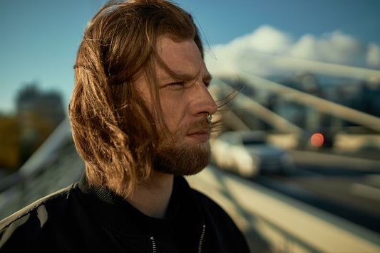A stylish man with shoulder-length hair styled neatly.