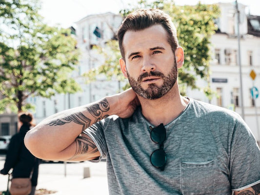 Man with a mid fade and textured top, smiling outdoors