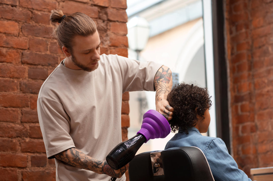 Barber blow-drying a man’s hair at a salon